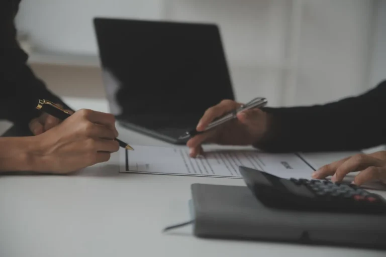 Pessoas discutindo documentos e calculadora sobre auxílio-doença pode ser acumulado com aposentadoria.